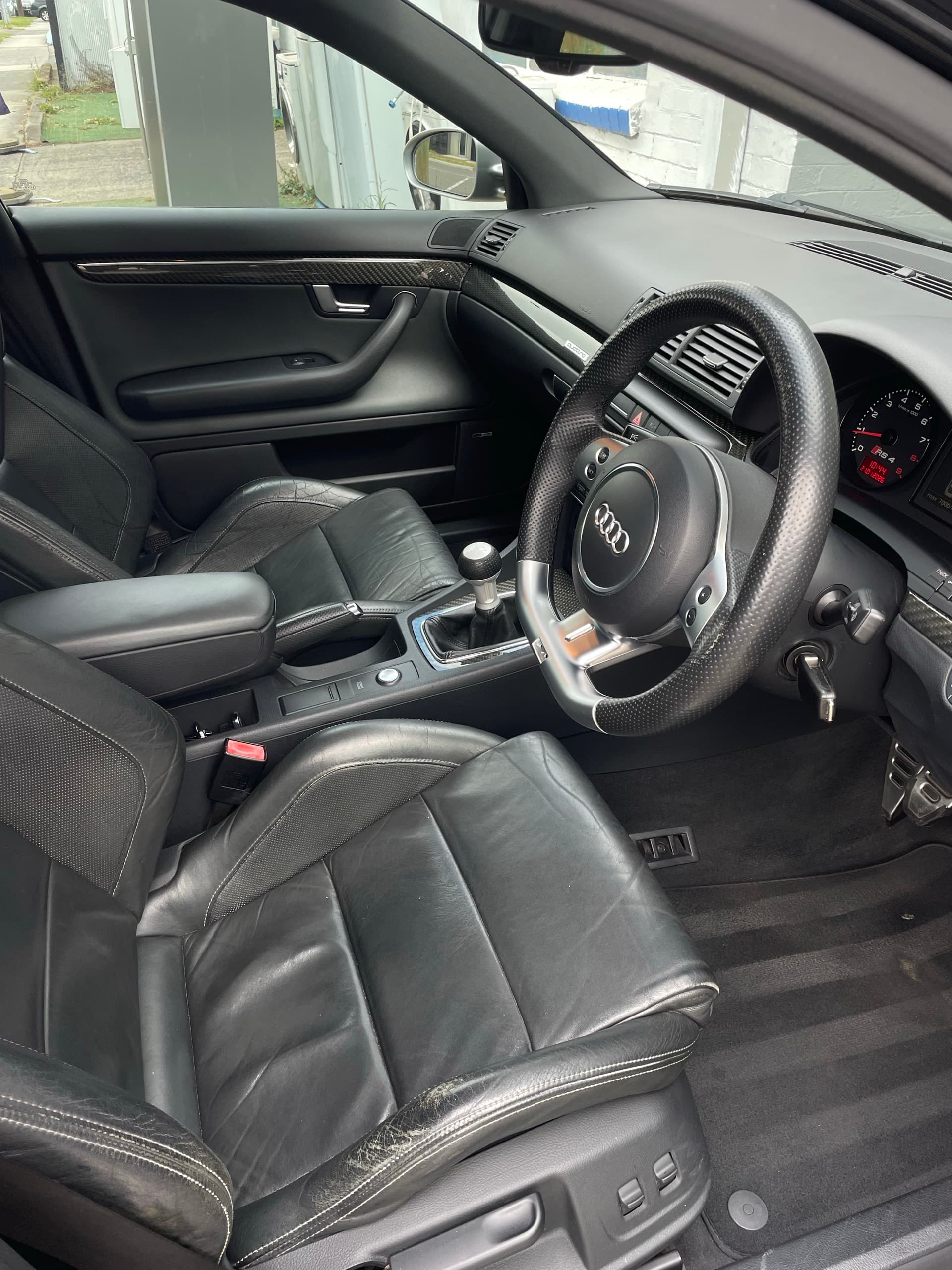Black leather front seats, steering wheel and dashboard inside an Audi RS4