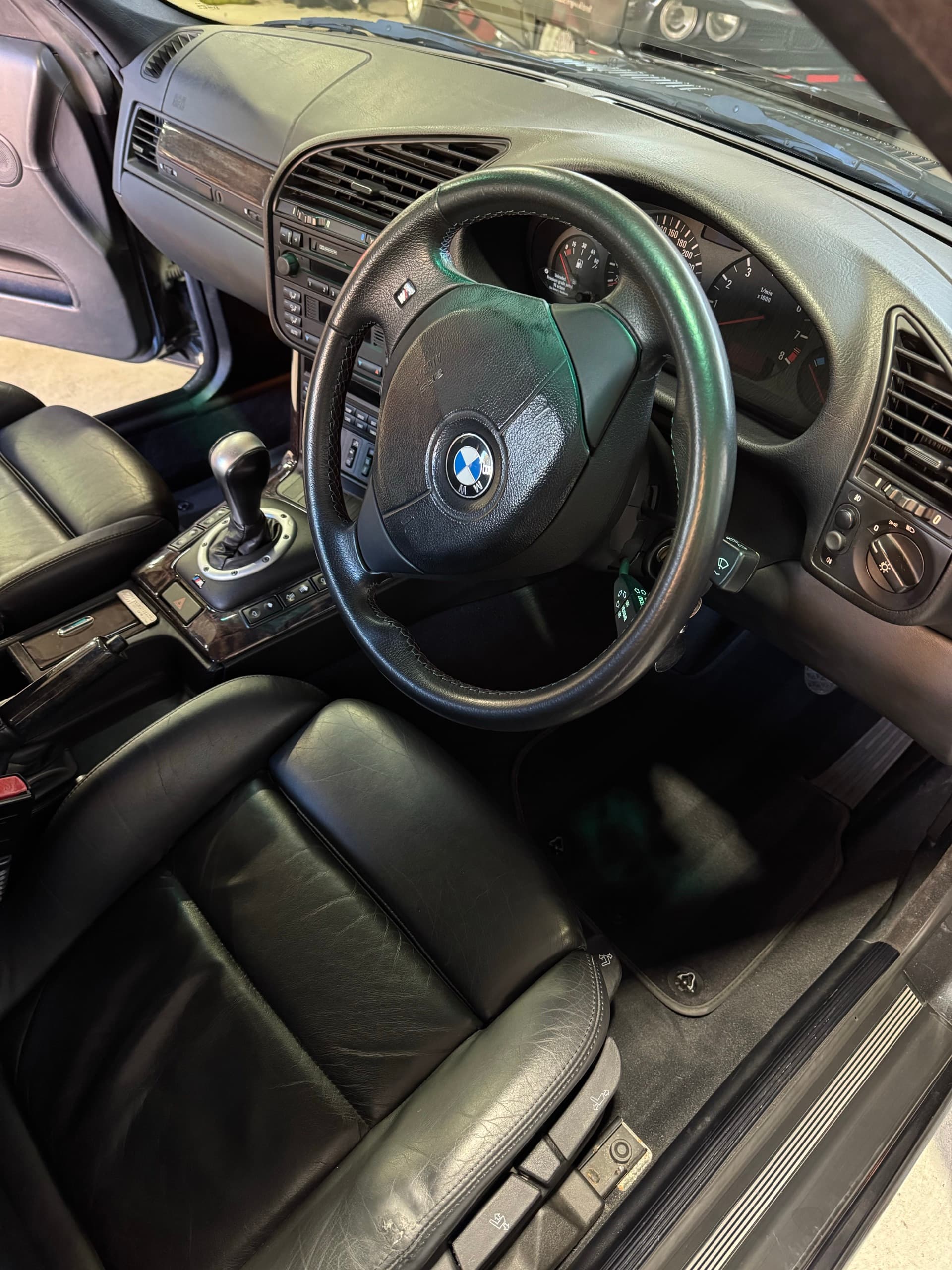 Black leather interior and steering wheel of a BMW E36 M3