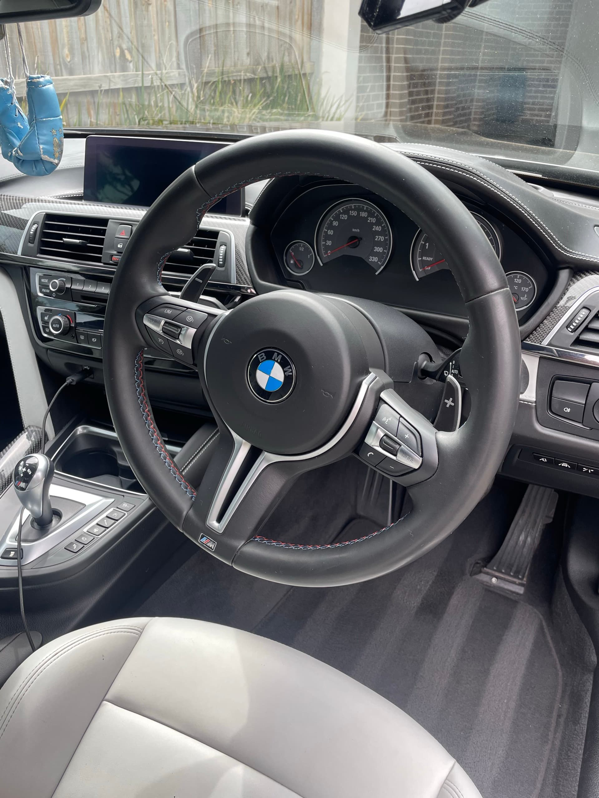 Steering wheel, dashboard and grey leather seat inside a BMW M4