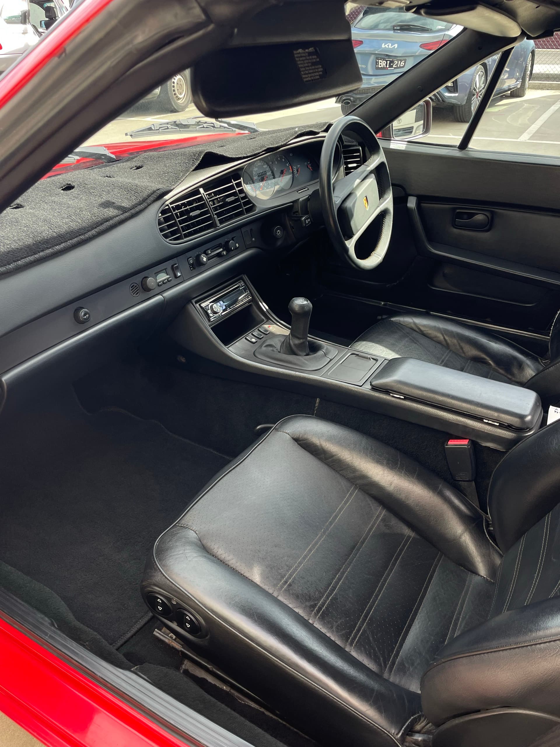 Black leather seats, steering wheel and dashboard inside a Porsche 944