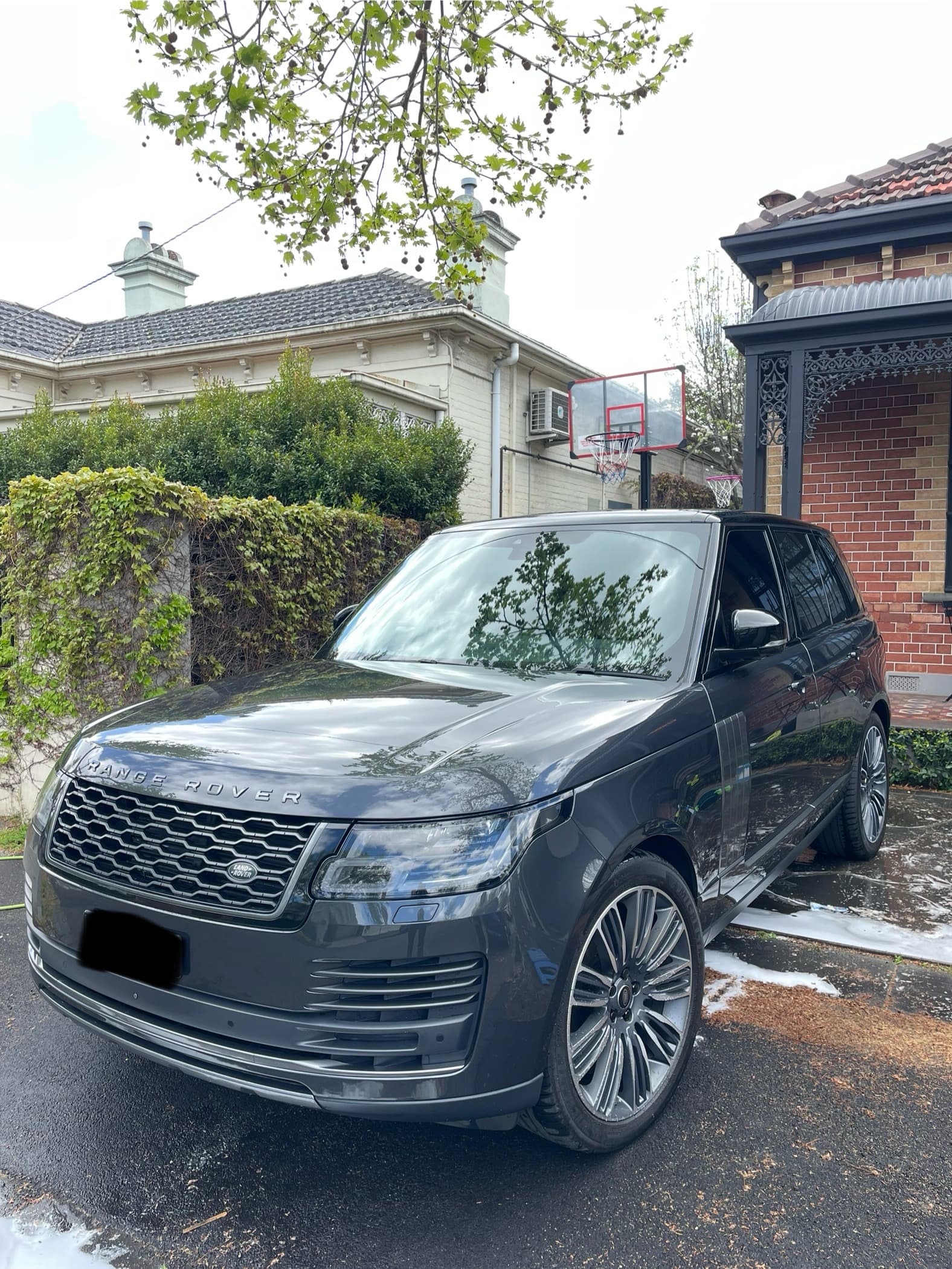 Front three-quarter view of a black Range Rover parked on a suburban street