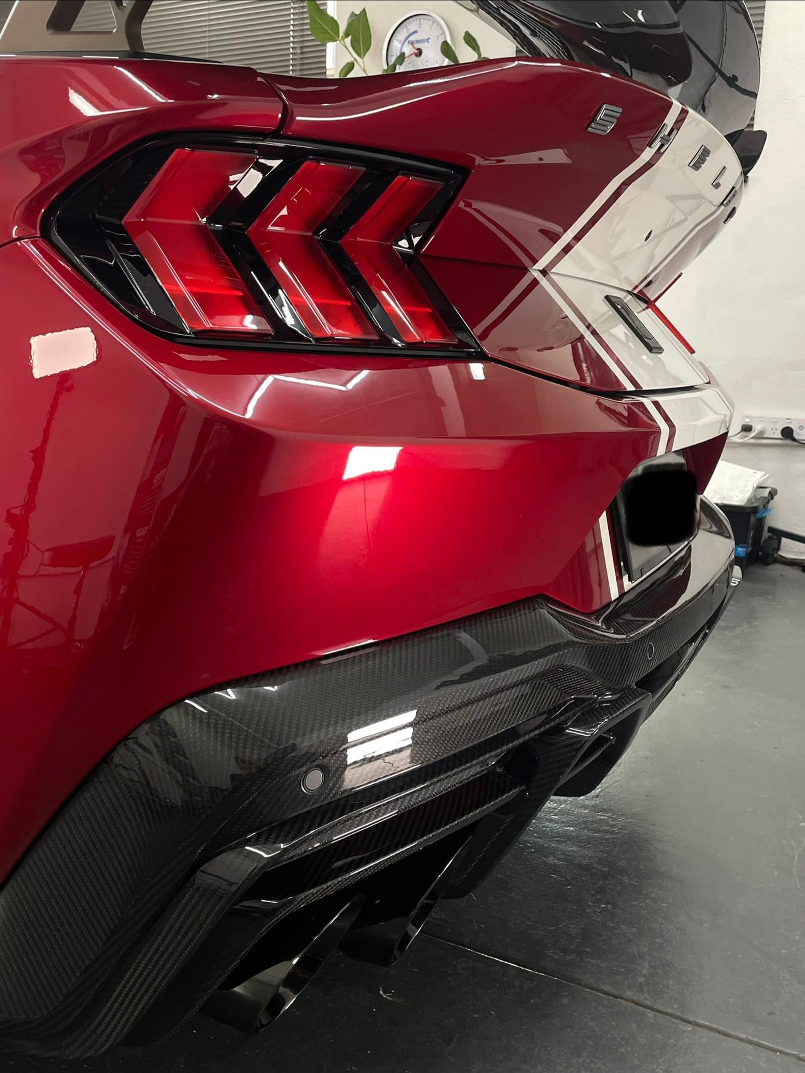 Rear of a red Ford Mustang Super Snake showing its tail lights, glossy paint and carbon diffuser